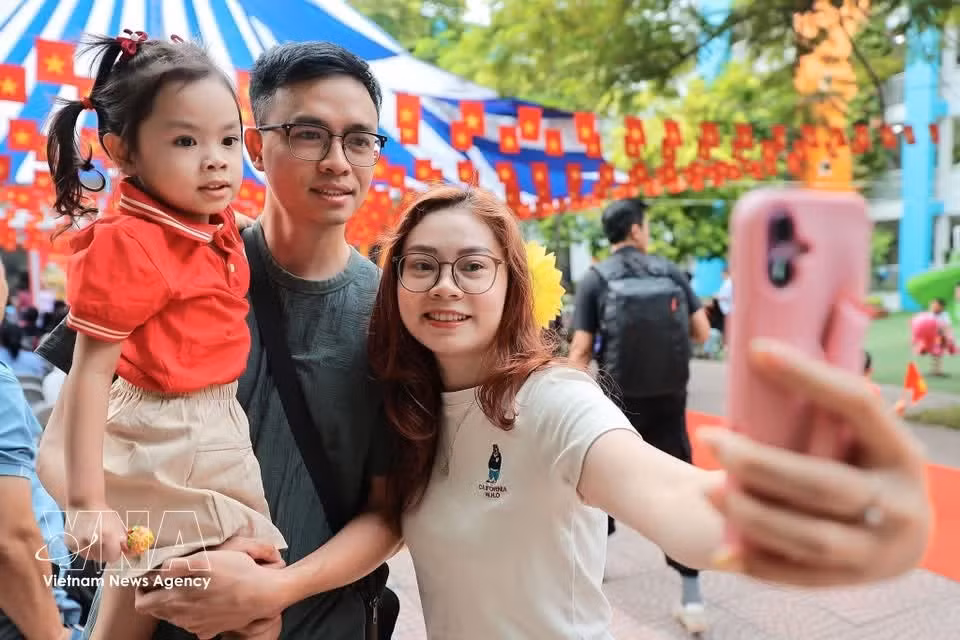 Родители фотографируют своих детей на память перед тем, как они входят в группу детского сада Кимлиен в Ханое. (Фото: ВИА)