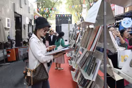 Посетители знакомятся с экспозицией самых популярных книжных изданий на Книжной улице города Хошимина (Фото: ВИА) 