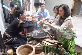 Туристы знакомятся с традиционным способом обжарки кофе народа Эдэ (Фото: nhandan.vn)