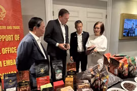 Торговый советник Чан Тху Куинь (справа) знакомит с продукцией высококачественного вьетнамского кофе председателя Канадской ассоциации кофе (второй слева) (Фото: ВИА)