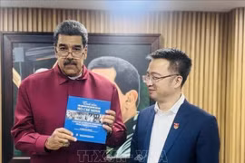 Президент Венесуэлы Николас Мадуро получает испанское издание «Привязанность людей мира к президенту Хо Ши Мину» от Нгуен Тыонг Лама (Фото: Посольство Вьетнама в Венесуэле)