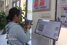 Жители сканируют QR-код для получения номера в Центре обслуживания населения квартала Хоа-суан (Дананг) (Фото: ВИА)