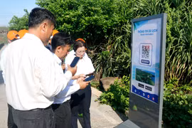 Туристы сканируют QR-код для быстрого доступа к туристической информации у объекта — флагштока суверенитета на территории специального административного округа Фукуи (Ламдонг) (Фото: ВИА)