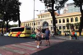 Иностранные туристы прогуливаются и осматривают Центральное почтовое отделение города Хошимин (Фото: ВИА)